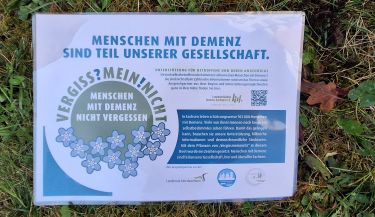 Zu sehen ist das Schild mit der Aufschrift "Menschen mit Demenz sind Teil unserer Gesellschaft."