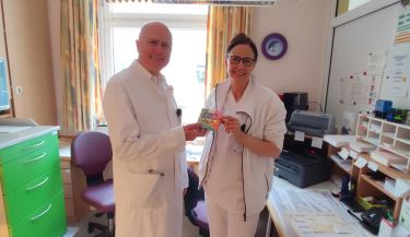 Zu sehen ist der Medizinische Geschäftsführer Herr Dr. Mario Günther bei der Übergabe der Pralinen an eine Stationsschwester.