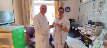 Zu sehen ist der Medizinische Geschäftsführer Herr Dr. Mario Günther bei der Übergabe der Pralinen an eine Stationsschwester.