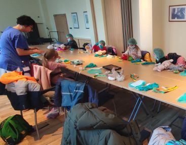 Das Bild zeigt die Kinder beim Verarzten ihrer Plüschtiere.