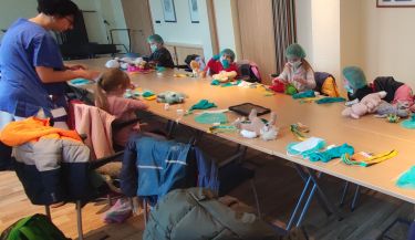 Das Bild zeigt die Kinder beim Verarzten ihrer Plüschtiere.