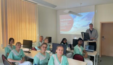 Zu sehen sind die Auszubildenden des ersten Lehrjahres mit dem Krankenhausseelsorger.