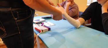 Es ist zu sehen, wie ein Arm eingegipst wird.