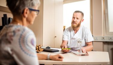 Zu sehen ist ein Arzt im Patientengespräch.