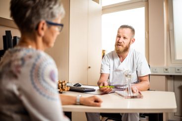 Zu sehen ist ein Arzt im Patientengespräch.