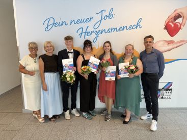 Zu sehen sind die Auszubildenden mit ihren Abschlusszeugnissen in der Hand und die Pflegedienstleitung.
