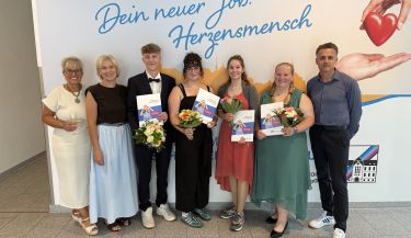 Zu sehen sind die Auszubildenden mit ihren Abschlusszeugnissen in der Hand und die Pflegedienstleitung.